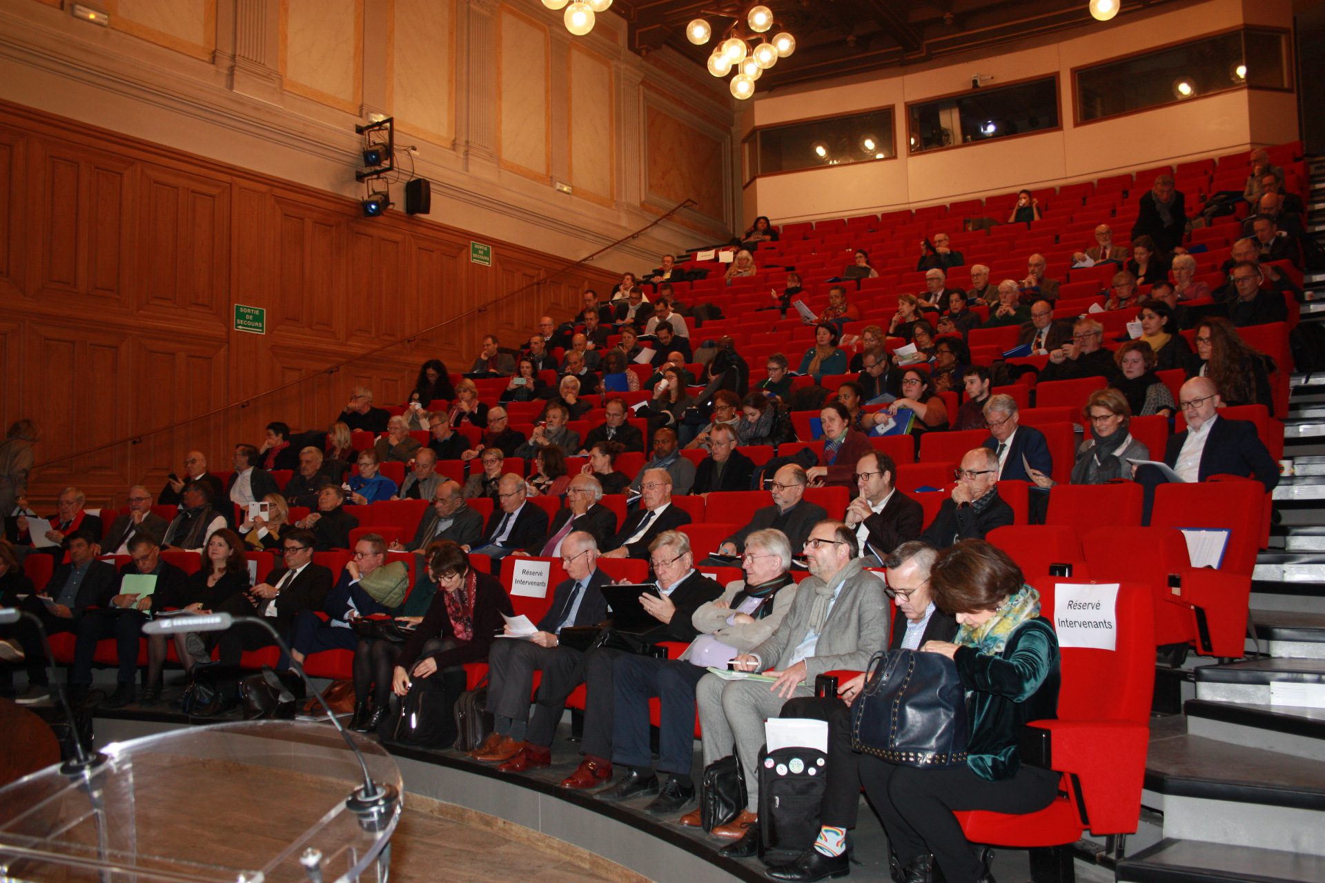 Promouvoir l'entrepreneuriat en France lors du Colloque AFDET 2020, où un groupe de personnes se réunit dans un grand auditorium.