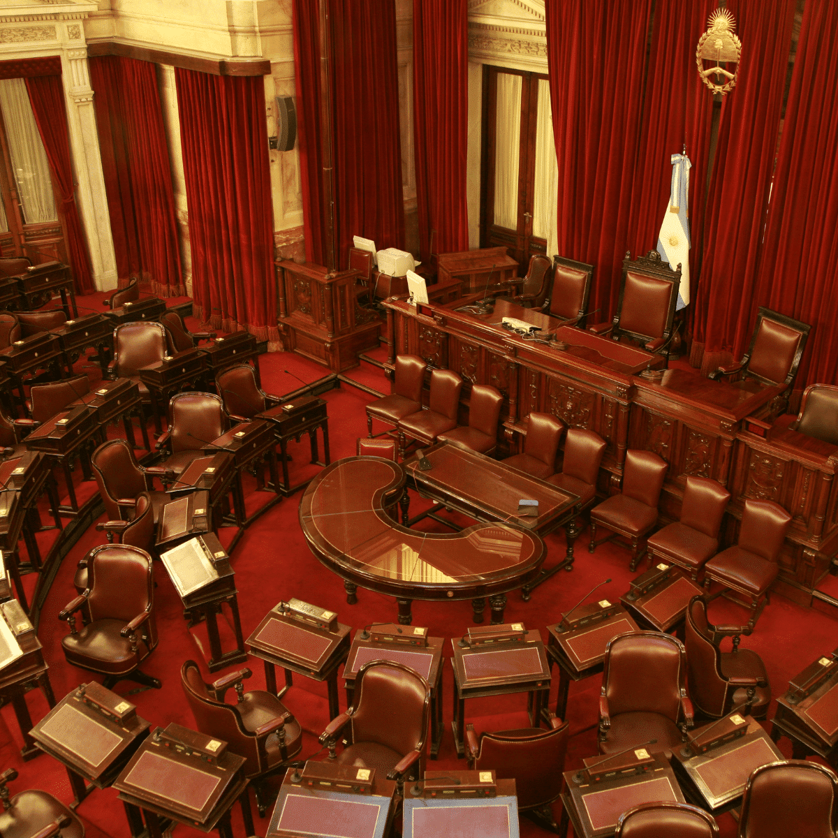 Rideaux rouges sur la scène du sénat.